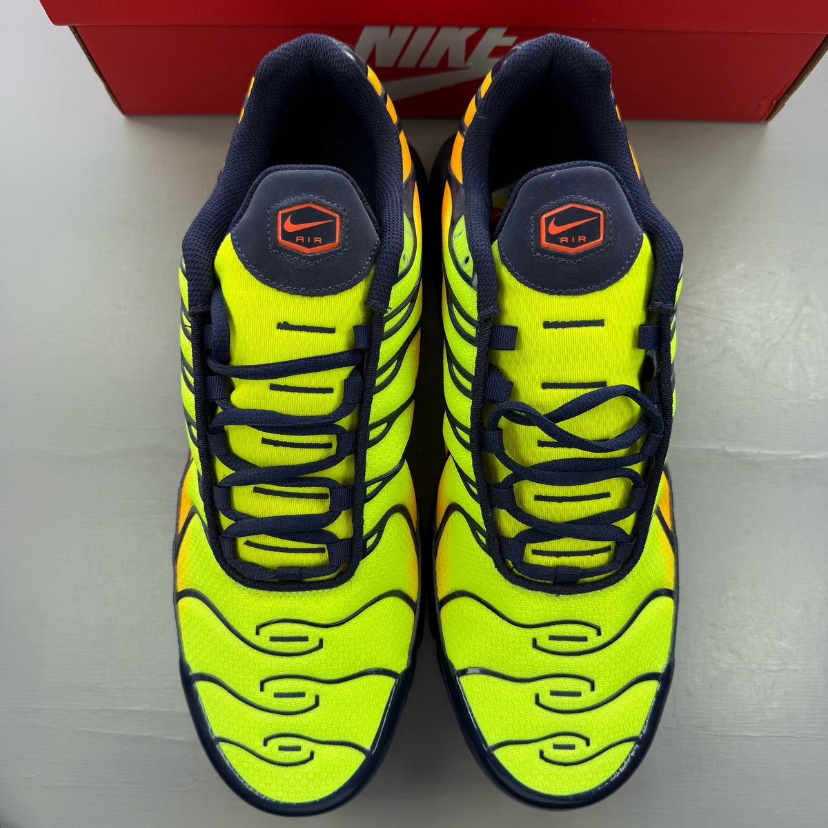 Nike Air Max Plus trainers yellow with Hyper Crimson accents and iconic TN logo.