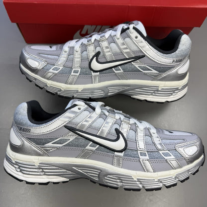 Nike P-6000 trainers metallic silver with white and grey accents, mesh material.