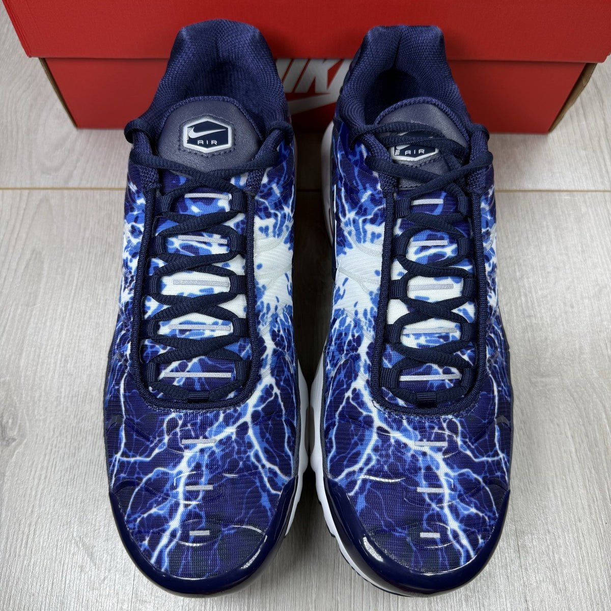 Nike Air Max Plus trainers blue with unique lightning pattern and signature logo.