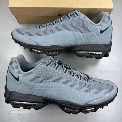 Nike Air Max 95 grey trainers with caution strip detailing and black accents.
