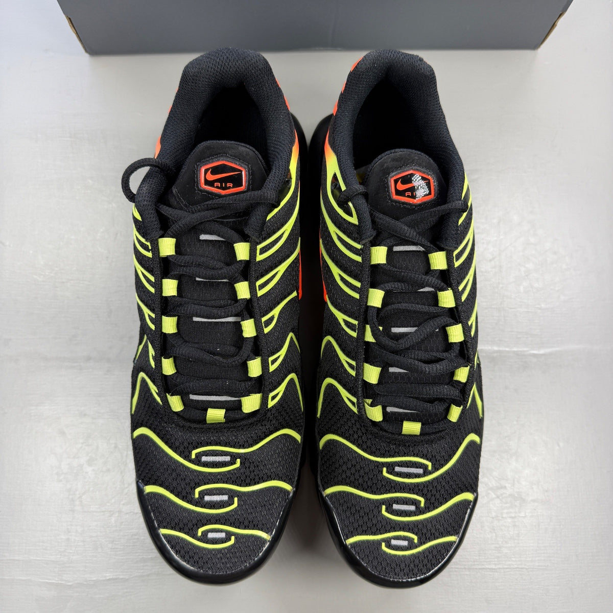 Nike Air Max Plus TN black with vibrant limelight and hyper crimson accents.