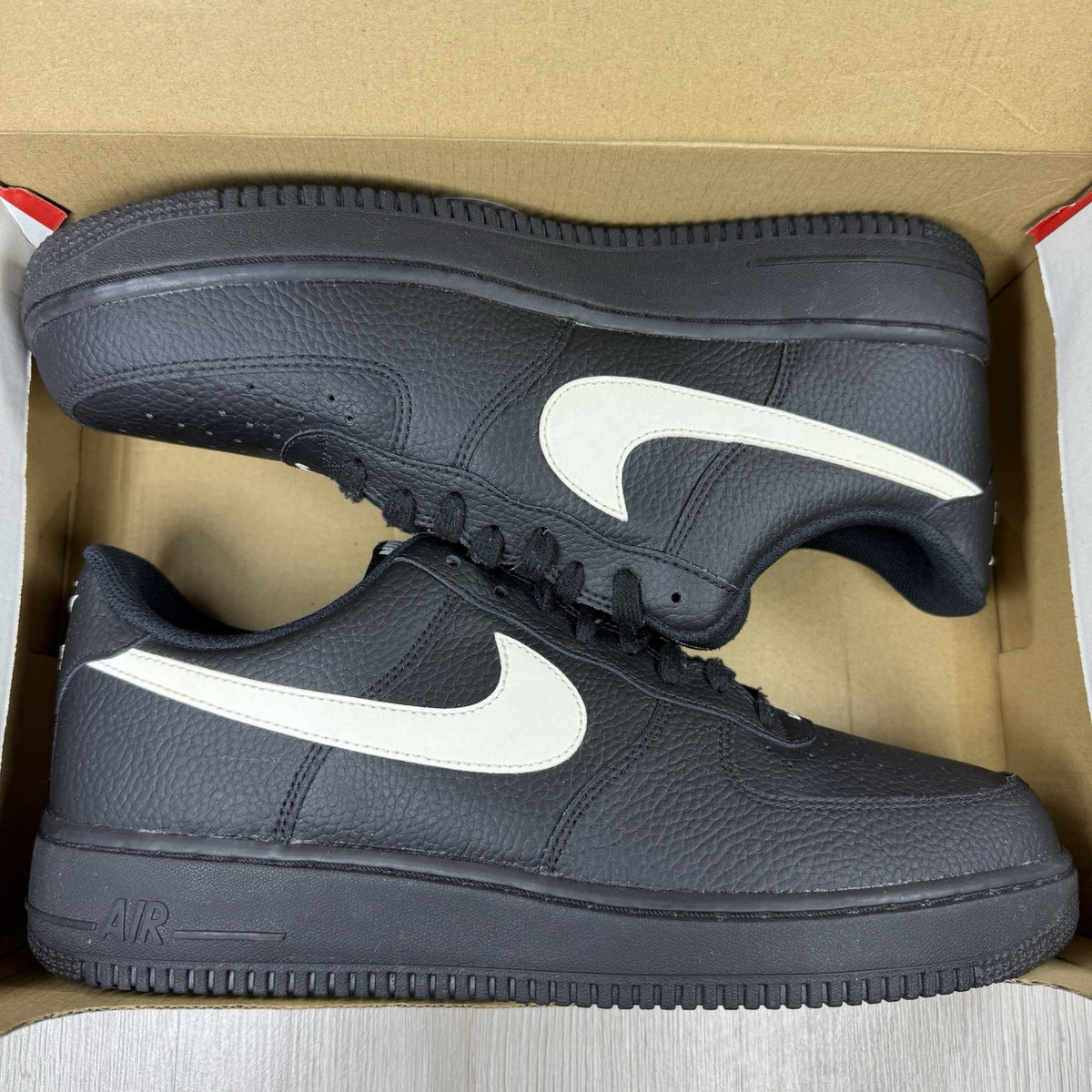 Nike Air Force 1 Low trainers black with white swoosh logo and sail accents.