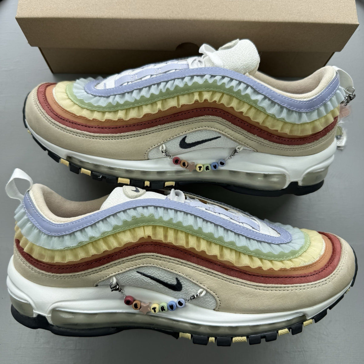 Nike Air Max 97 trainers white with pink accents and beige detailing, authentic design.