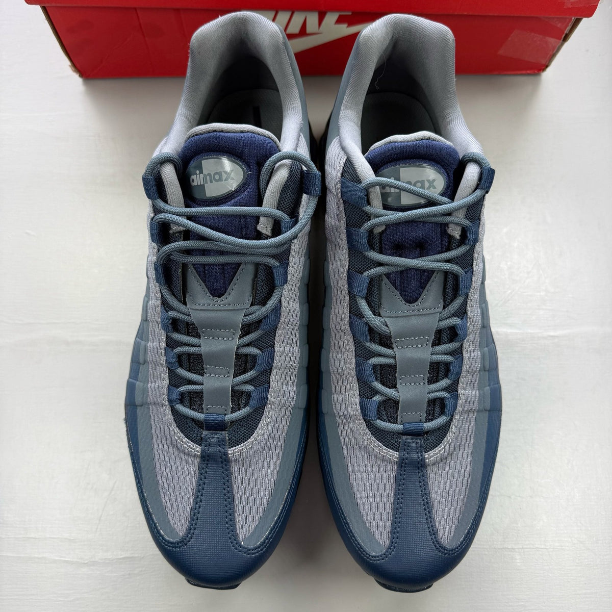 Nike Air Max 95 blue trainers with mesh upper and rubber sole, featuring logo detail.
