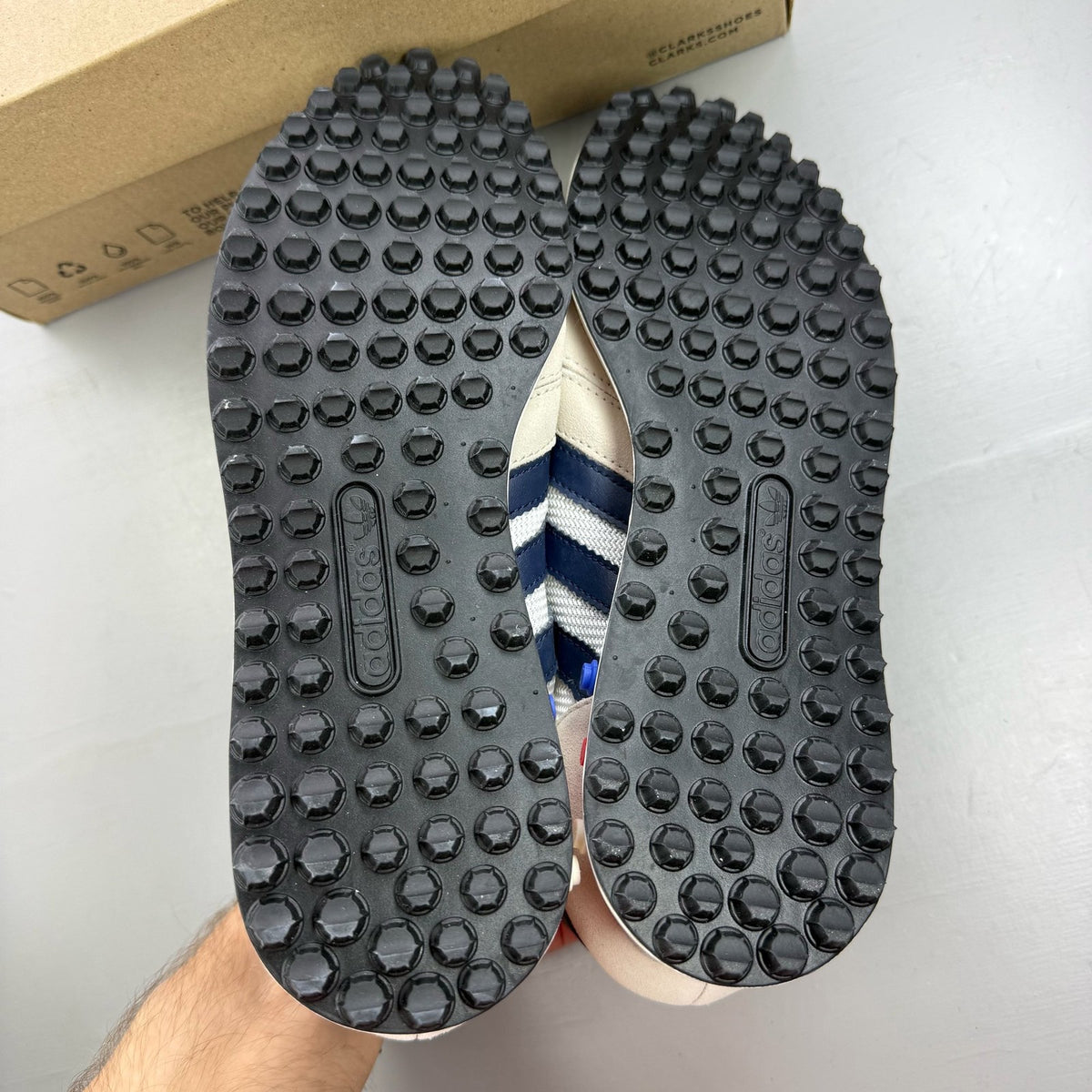 Adidas white LA Trainer sneakers with navy accents and classic three-stripe logo.