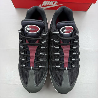 Nike black trainers with red accents and grey detailing, featuring iconic Air Max design.