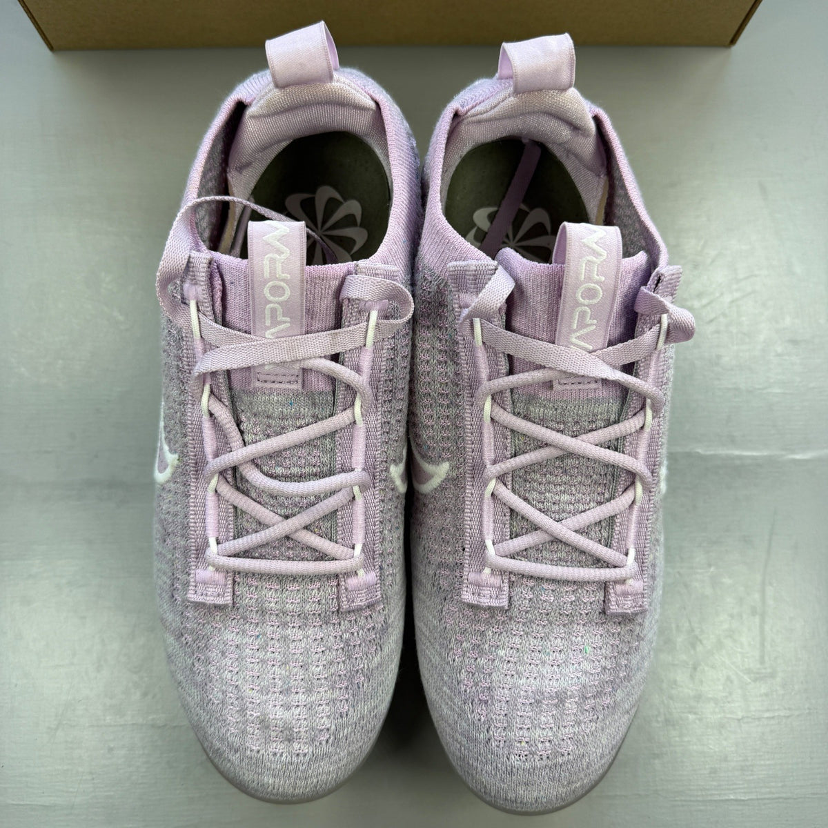 Nike trainers pink Flyknit upper with Air cushioning and logo detail.