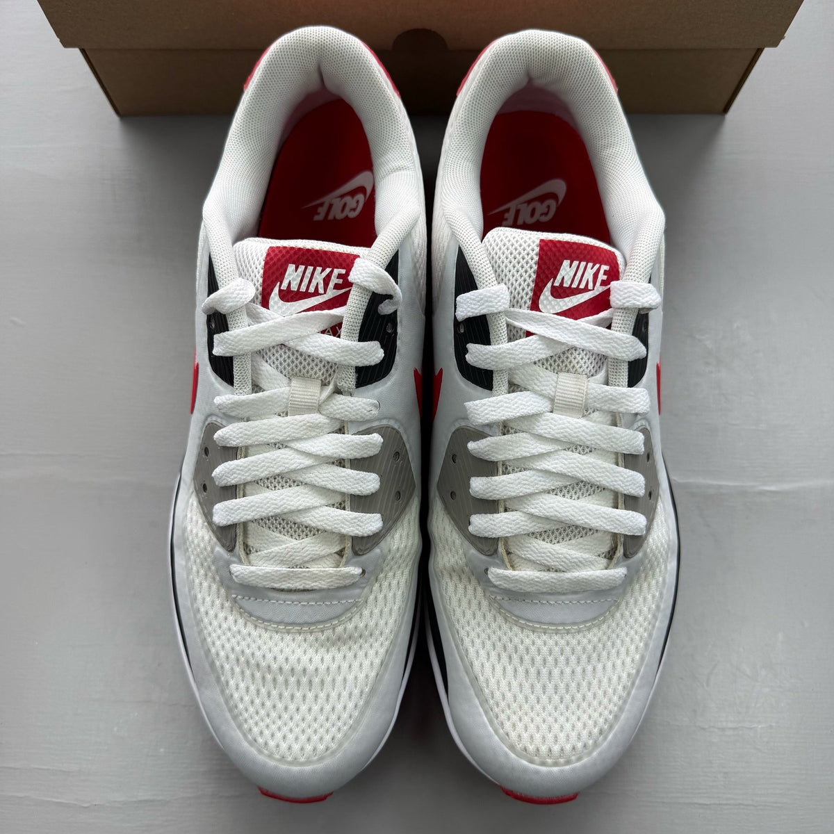 Nike Air Max 90 white trainers with red accents and logo, used condition.