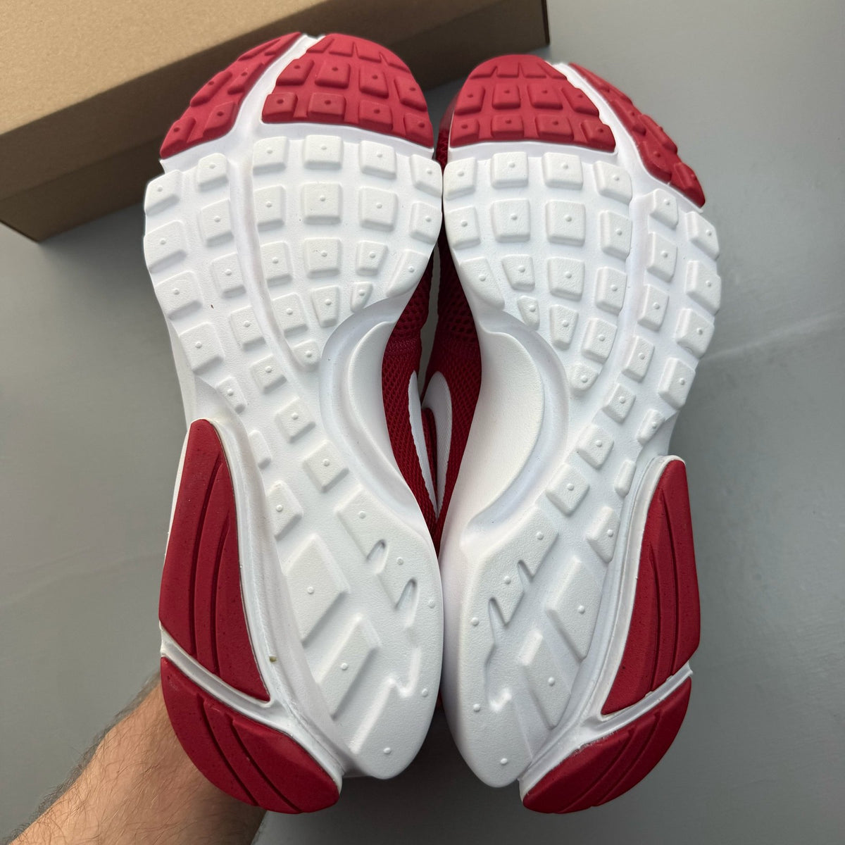 Nike Presto Fly red trainers with white accents and logo detail.