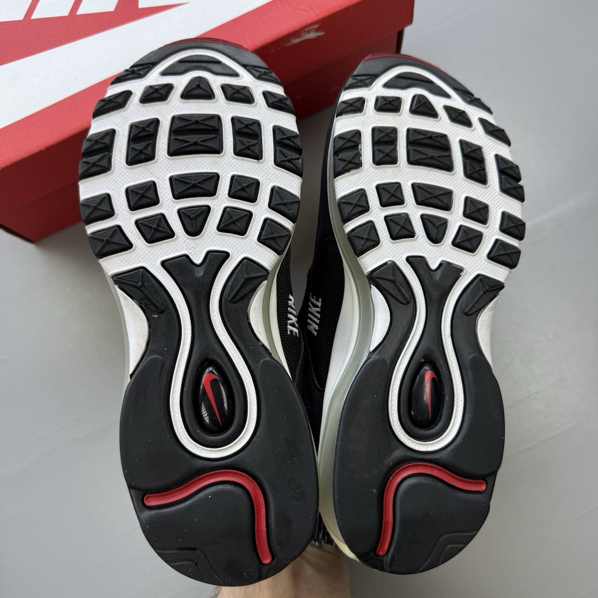Nike Air Max 97 SE black trainers with white and varsity red accents, mesh and leather material.