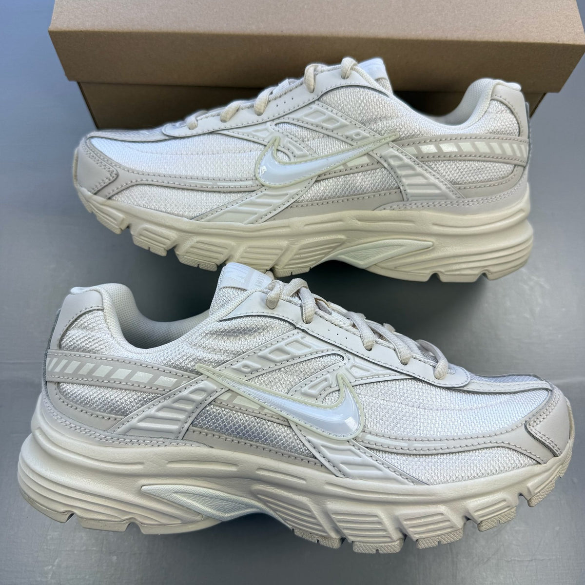Nike white trainers with light orewood brown accents and swoosh logo.