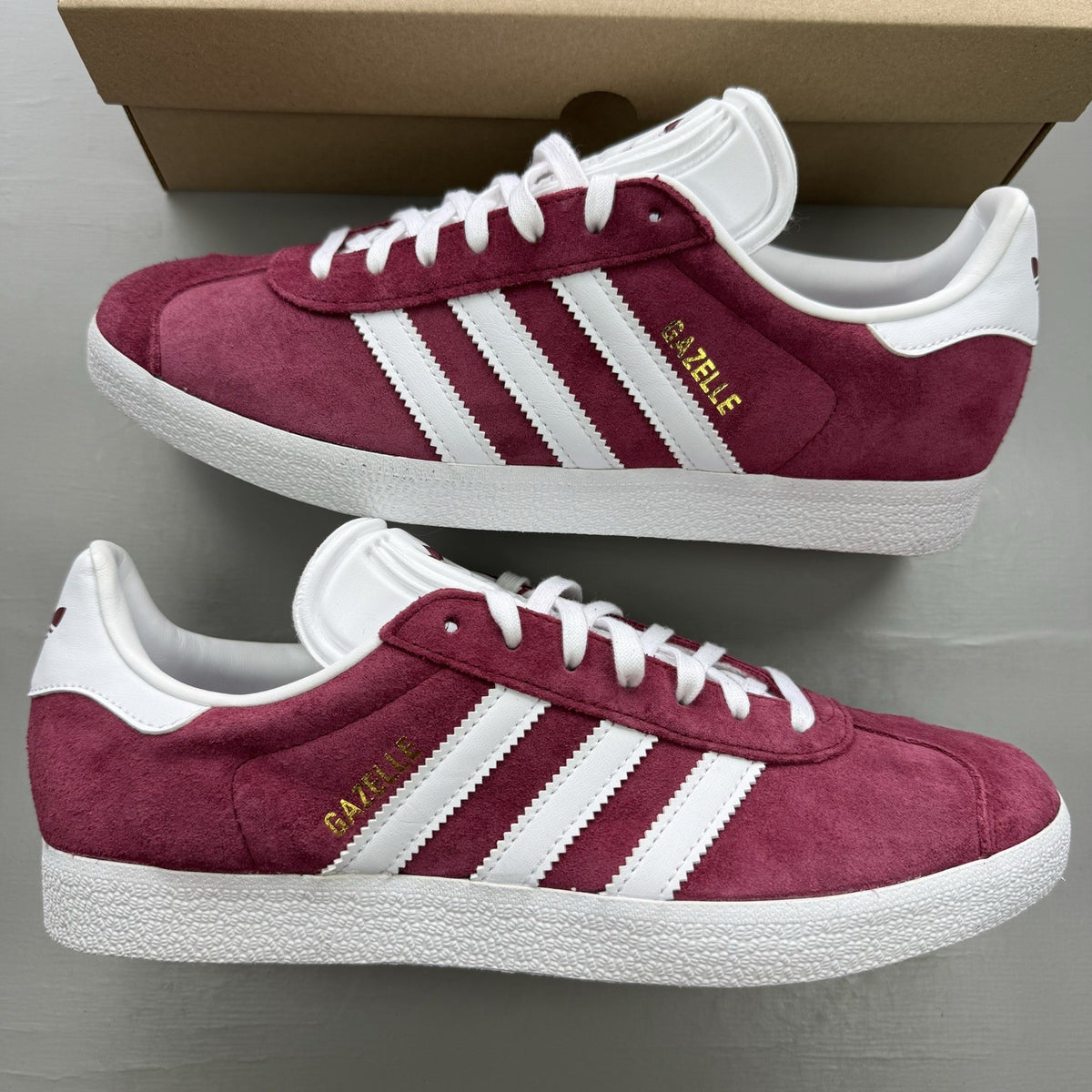 Adidas Gazelle trainers burgundy with white and gold accents, classic suede material.