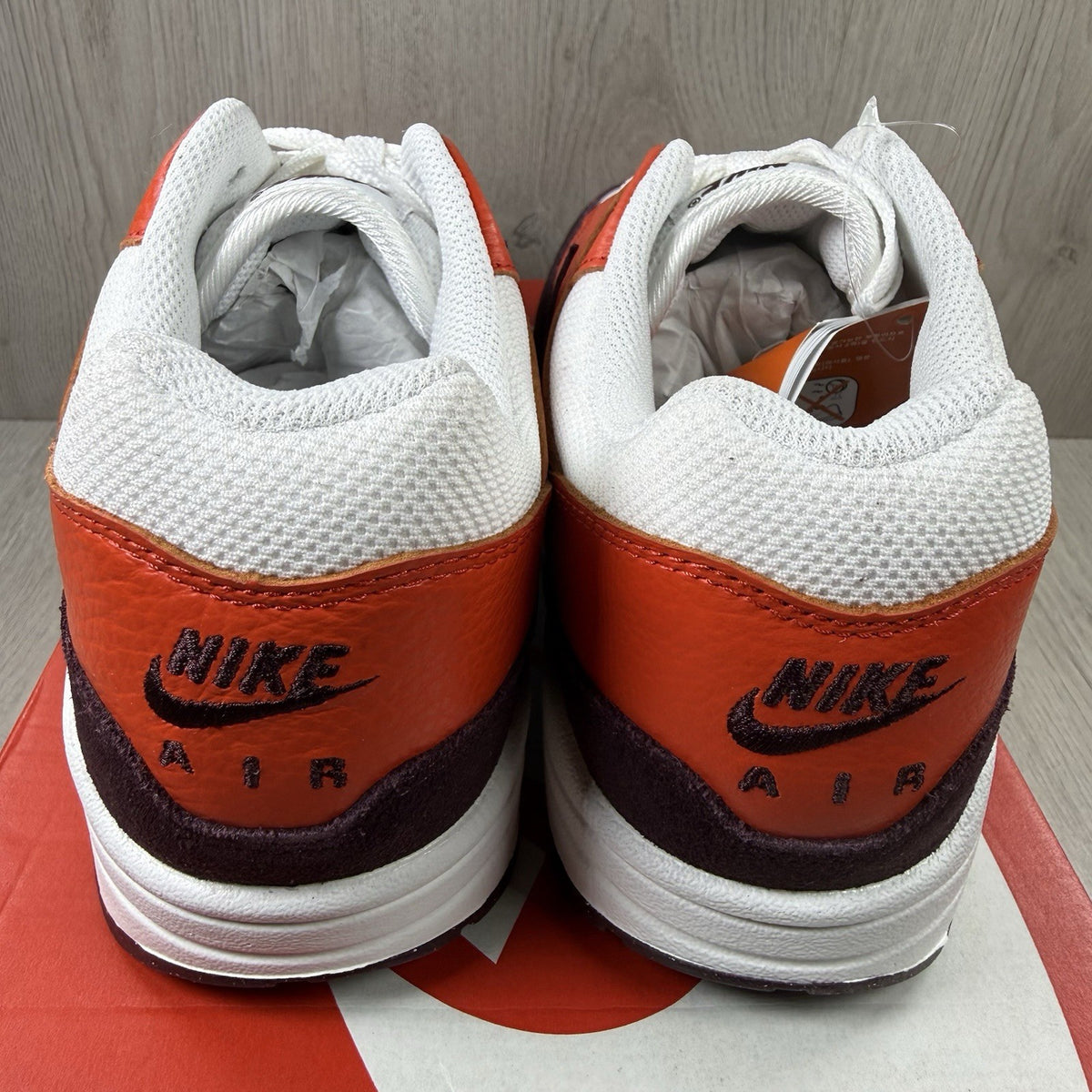 Nike Air Max 1 red trainers with white accents and signature swoosh logo.