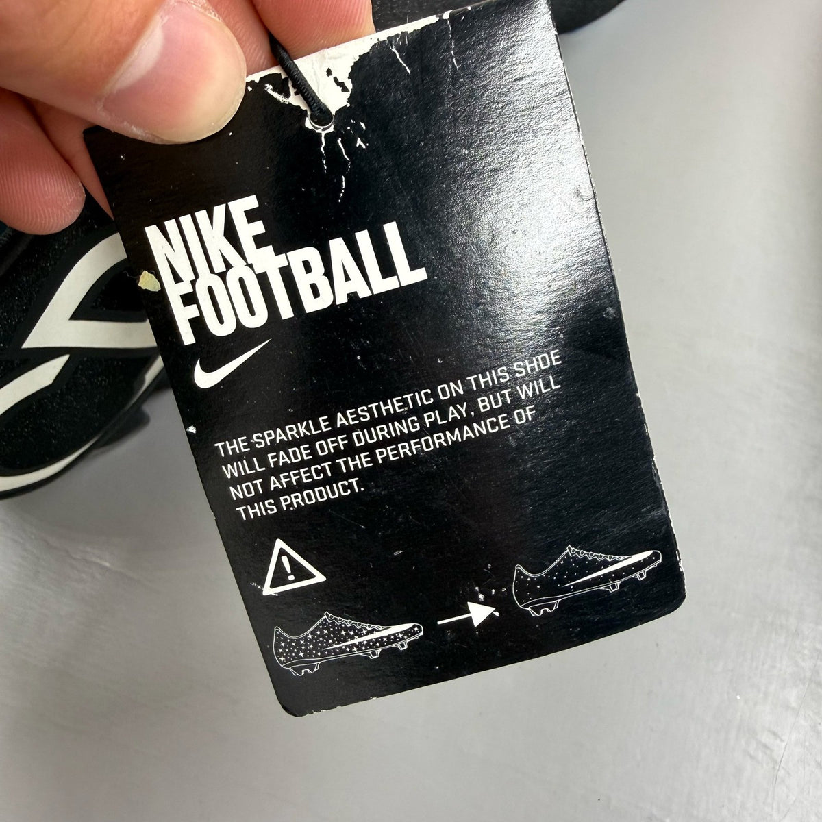 Nike black football boots with white Mercurial logo, sleek design, synthetic material.