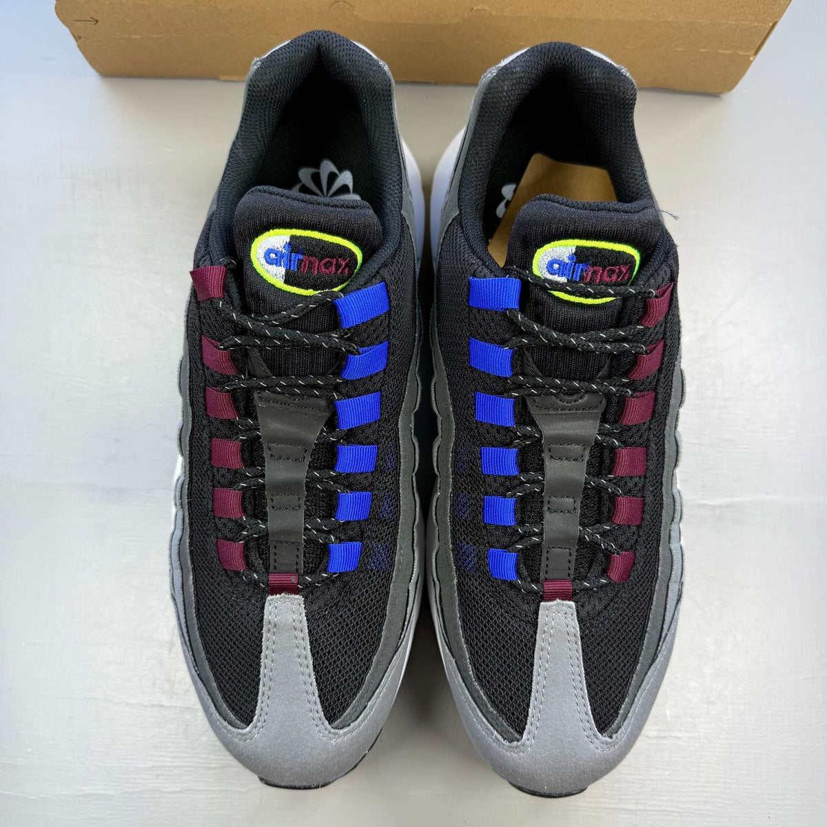 Nike Air Max 95 black trainers with grey and white accents, featuring iconic logo details.