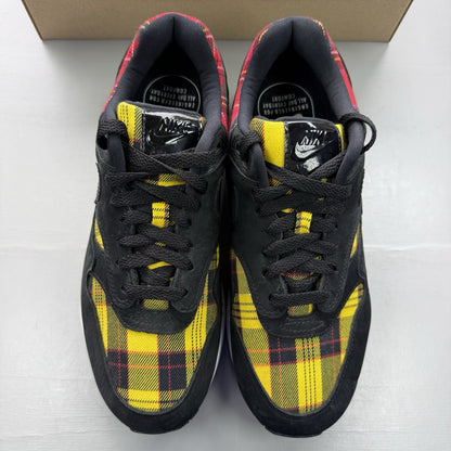 Nike Air Max 1 SE trainers black with tartan pattern and yellow accents.