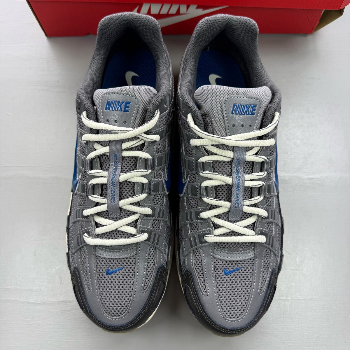 Nike grey blue trainers with pencil point design and logo detail.