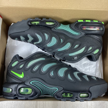 Nike Air Max Plus trainers black with volt green accents and signature swoosh logo.