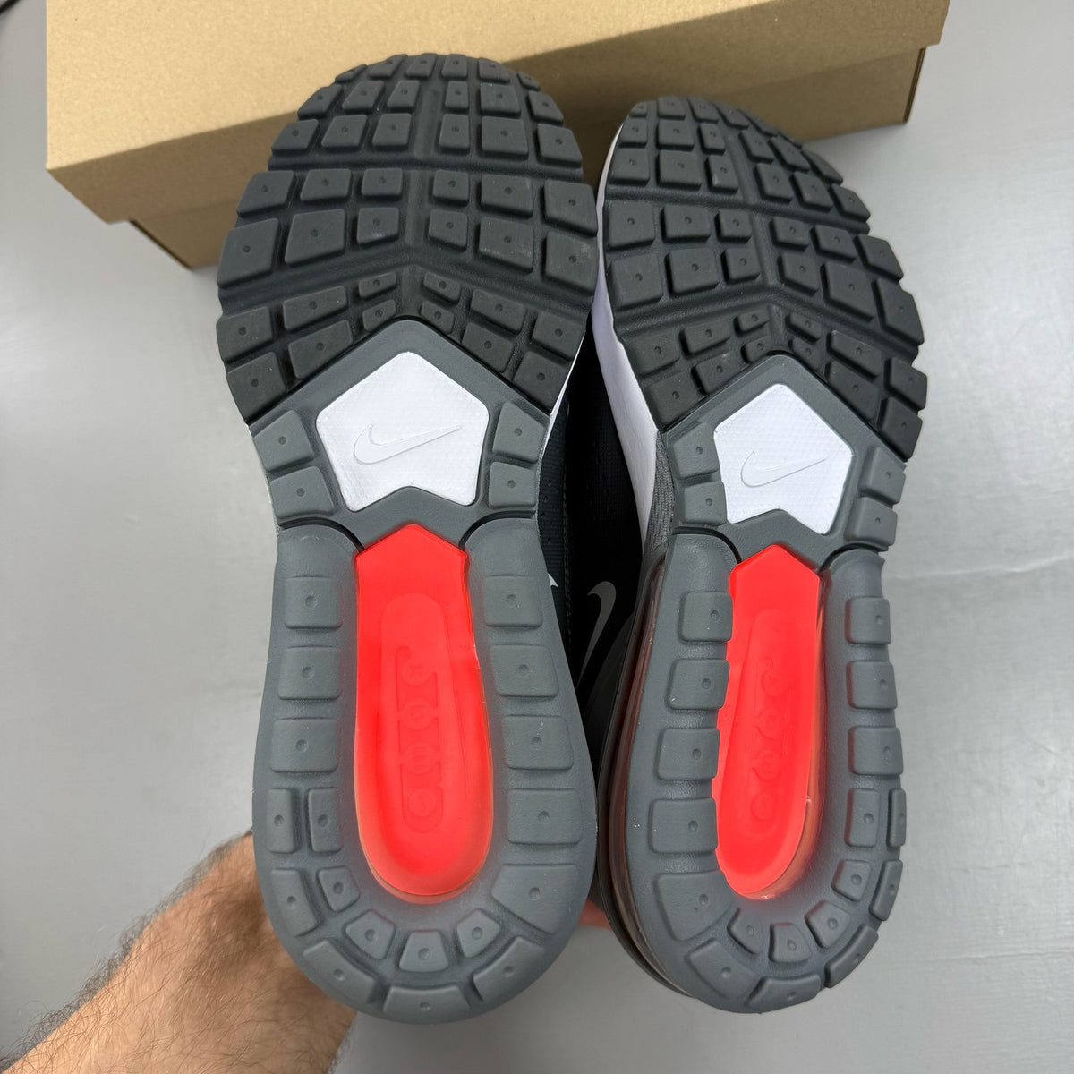 Nike black Air Max Pulse trainers with bright crimson accents and logo detail.