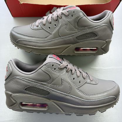 Nike Air Max 90 trainers grey with red accents and logo detail.