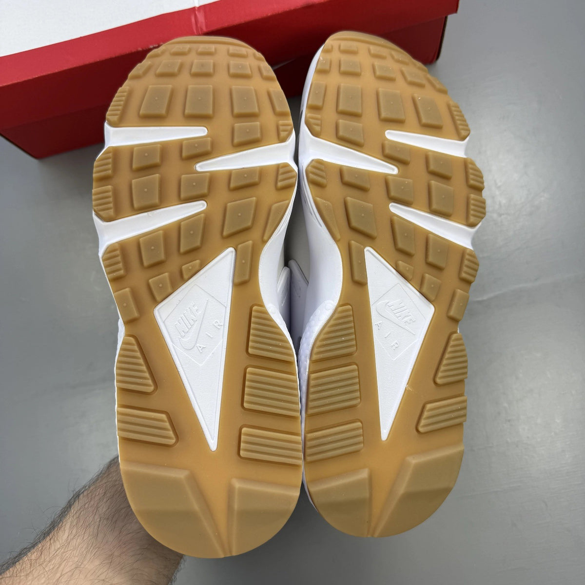 Nike white Air Huarache trainers with gum sole and logo detailing.
