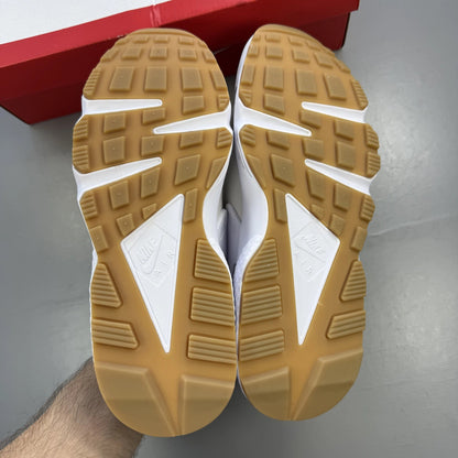 Nike white Air Huarache trainers with gum sole and logo detailing.