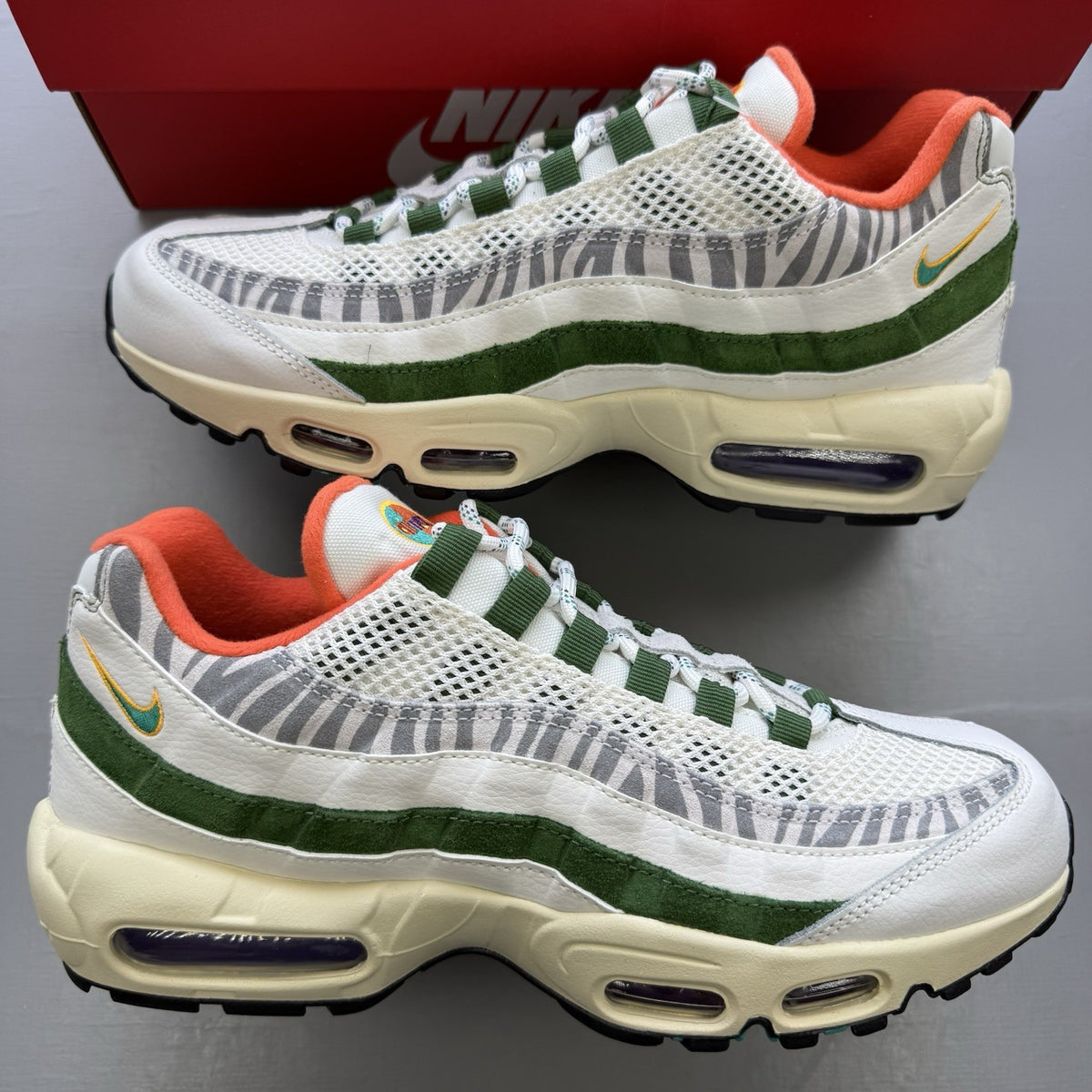 Nike Air Max 95 trainers white with safari green accents and textured material.