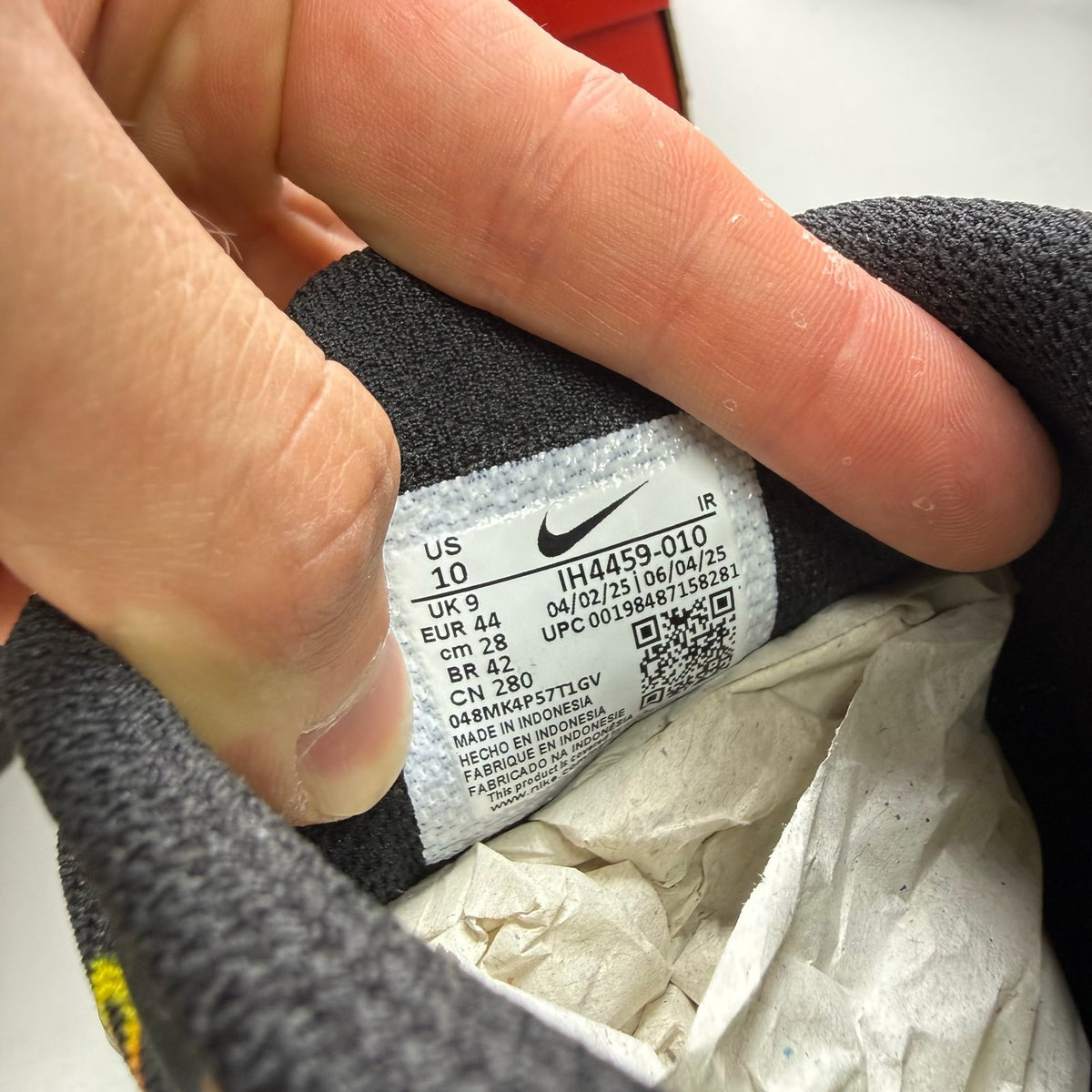 Nike black trainers with Tuned Air technology and sunrise pattern accents.