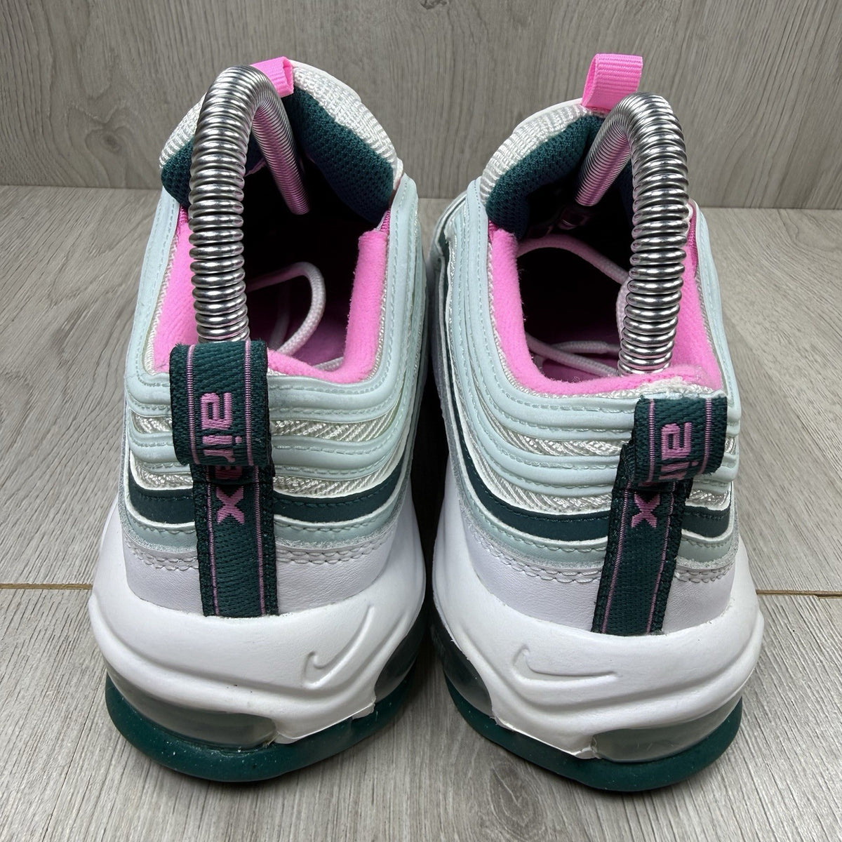 Nike Air Max 97 white trainers with teal accents and reflective detailing.