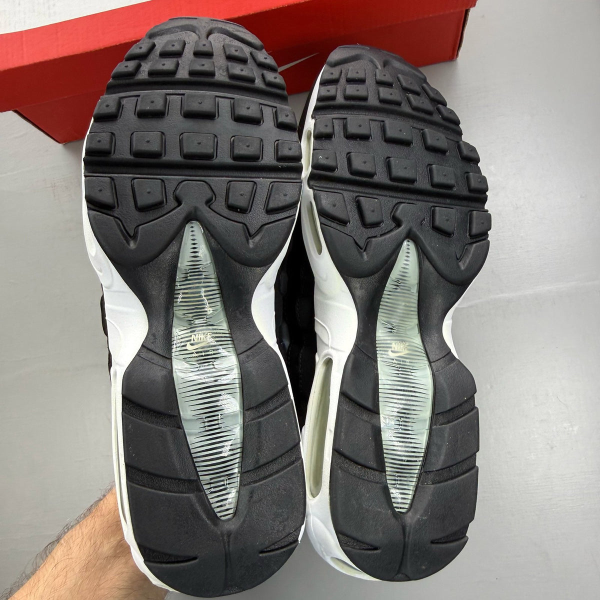 Nike Air Max 95 black trainers with grey and white accents, featuring iconic logo.