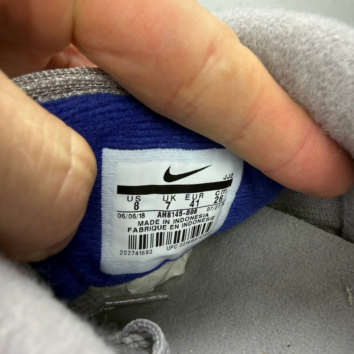 Nike Air Max 1 grey trainers with royal blue accents and signature logo.