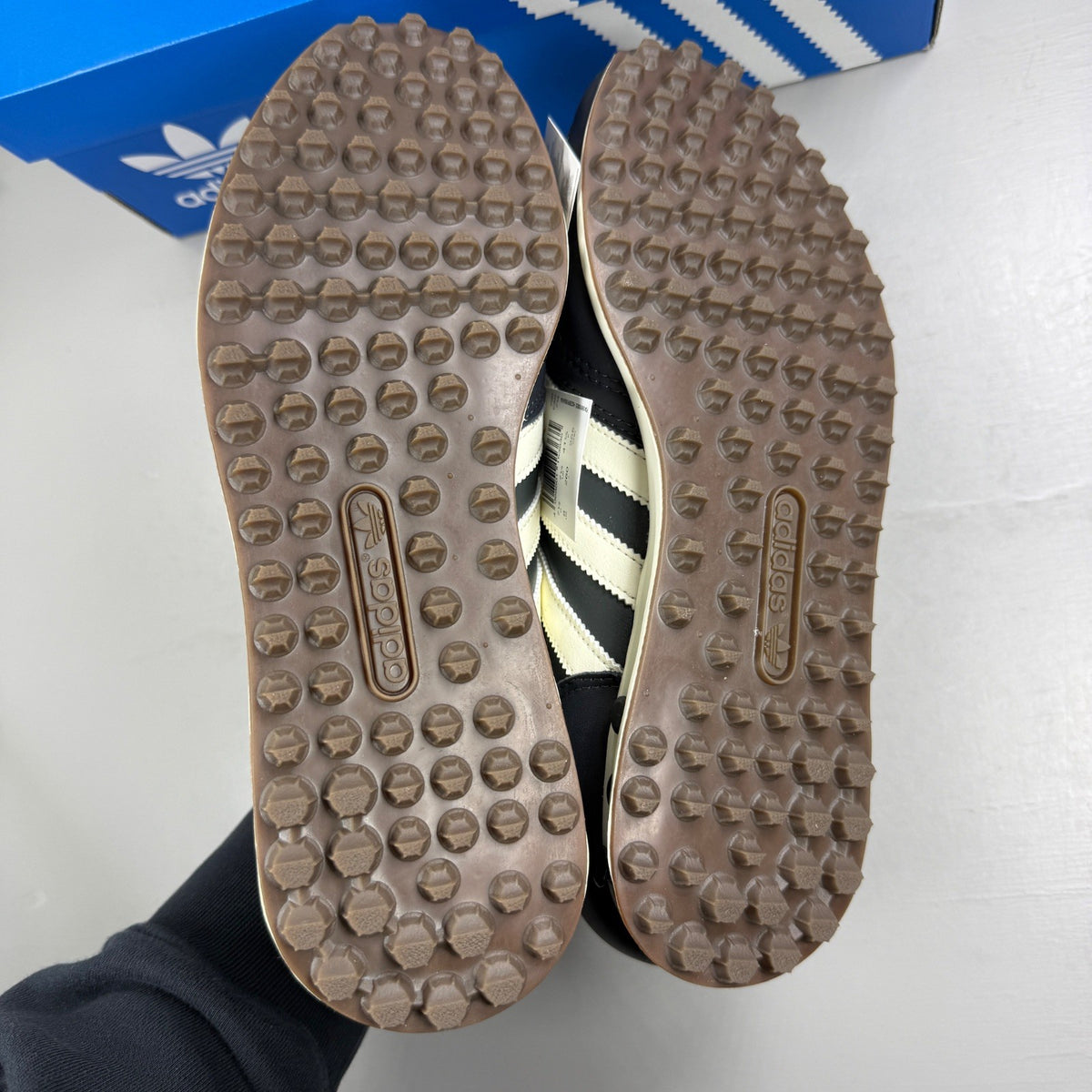 Adidas black deck shoes with blue and white accents, featuring classic logo design.