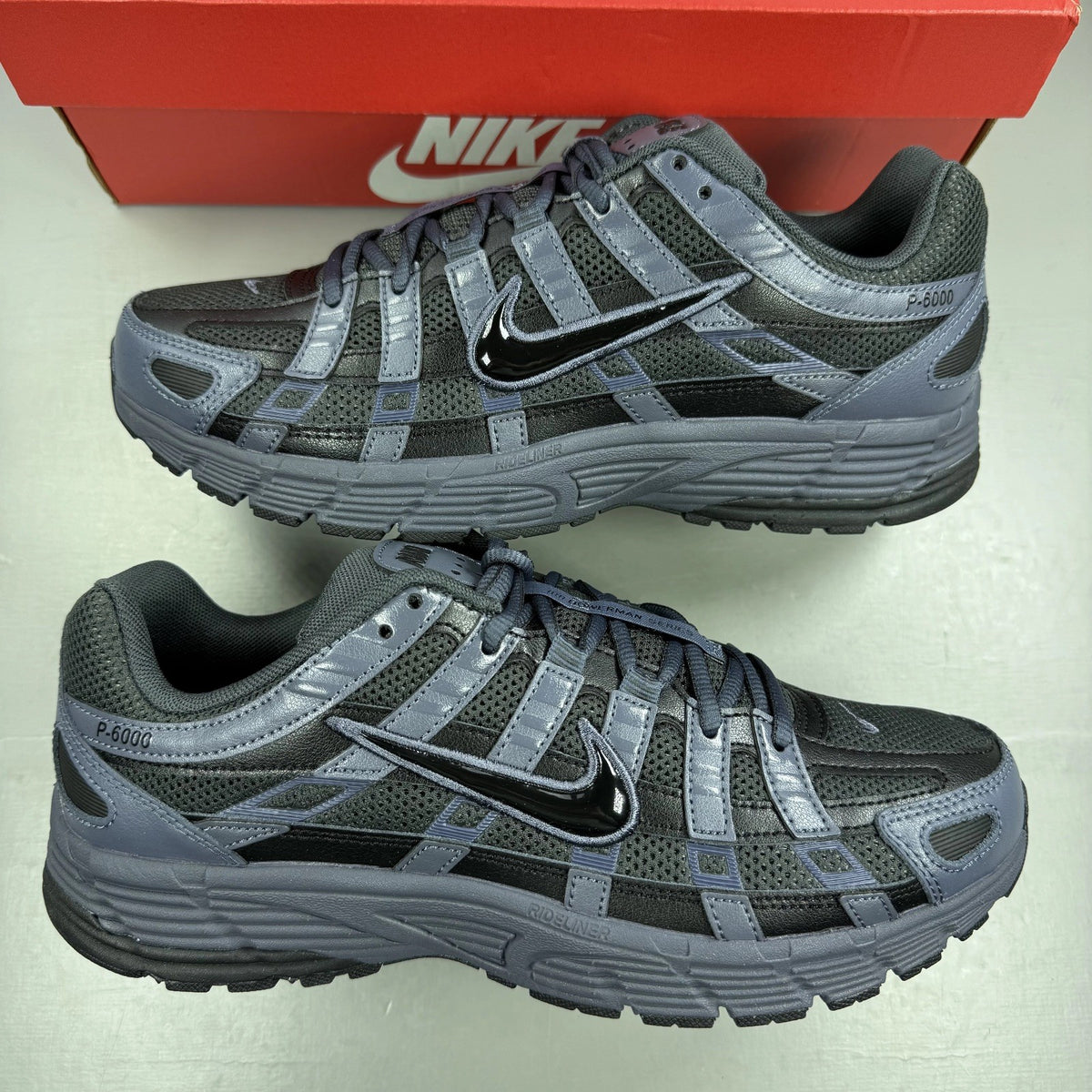 Nike P-6000 grey trainers with black accents and logo detailing.