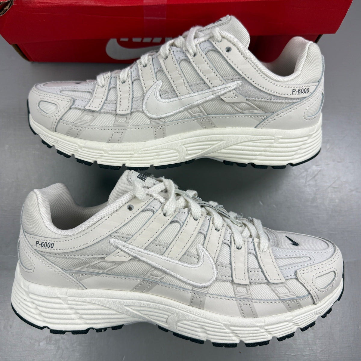 Nike beige athletic shoes with white accents and light bone detailing.