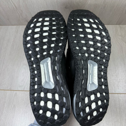 Adidas black trainers with white polka dot pattern and iconic three-stripe logo.