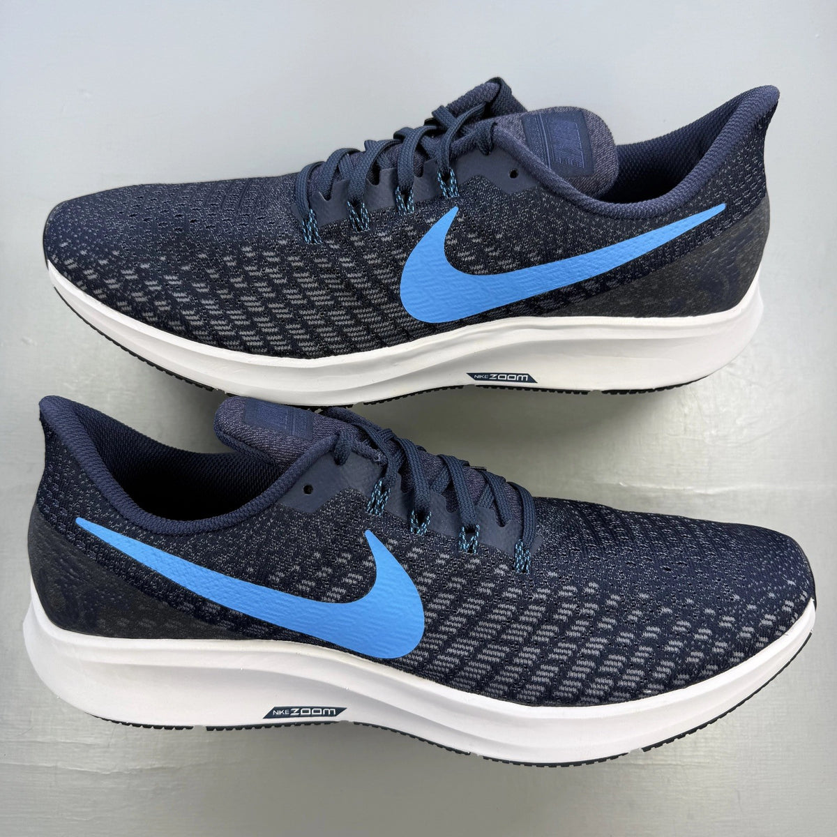 Nike blue trainers with Air Zoom cushioning and logo detailing on the side.