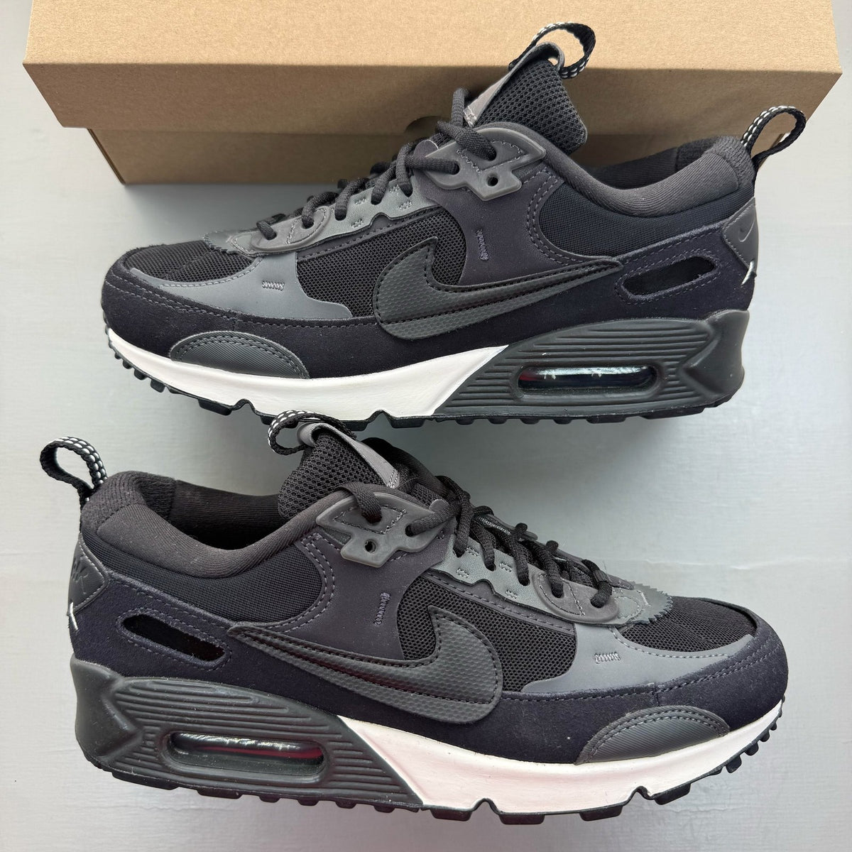 Nike black Air Max 90 Futura trainers with grey accents and logo detail.