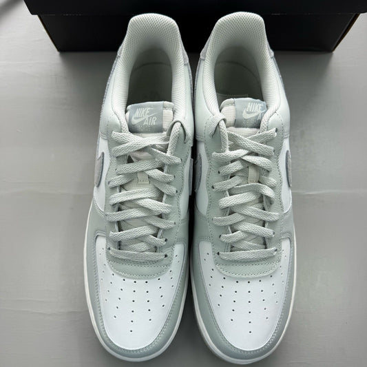 Nike Air Force 1 grey low-top sneakers with light silver accents and white sole.