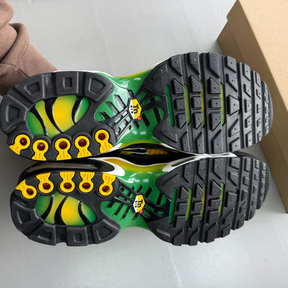 Nike Air Max Plus TN yellow trainers with green accents and signature swoosh logo.