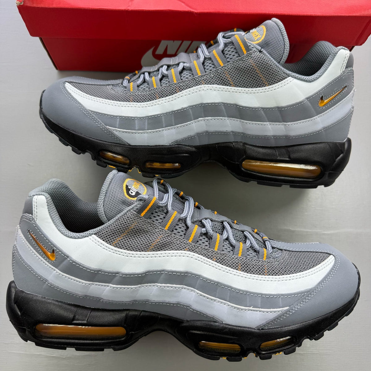 Nike Air Max 95 grey trainers with sundial accents and mesh material.