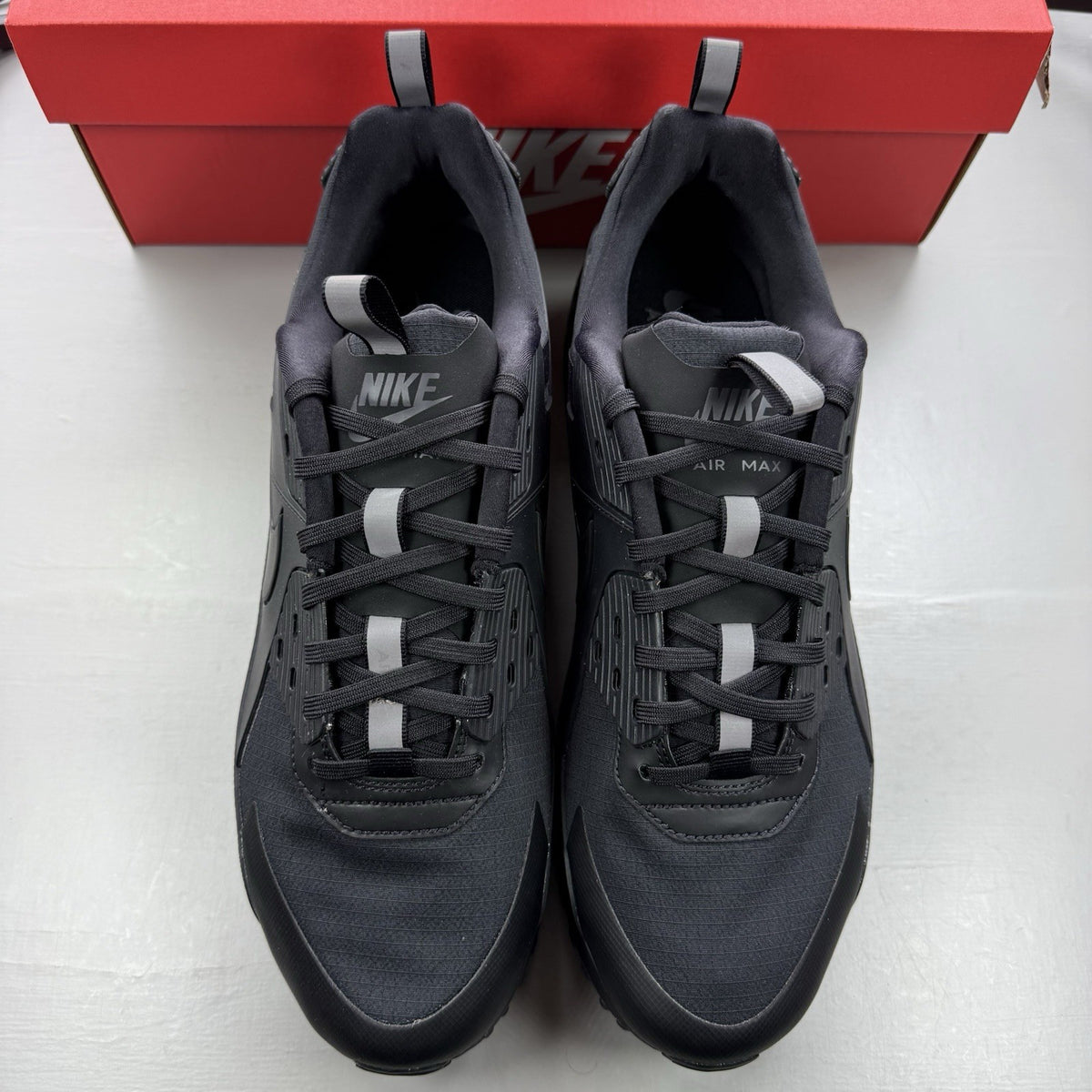 Nike Air Max 90 Drift black trainers with textured upper and signature logo.