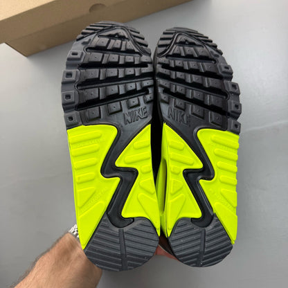 Nike Air Max 90 black trainers with volt accents and signature logo detailing.