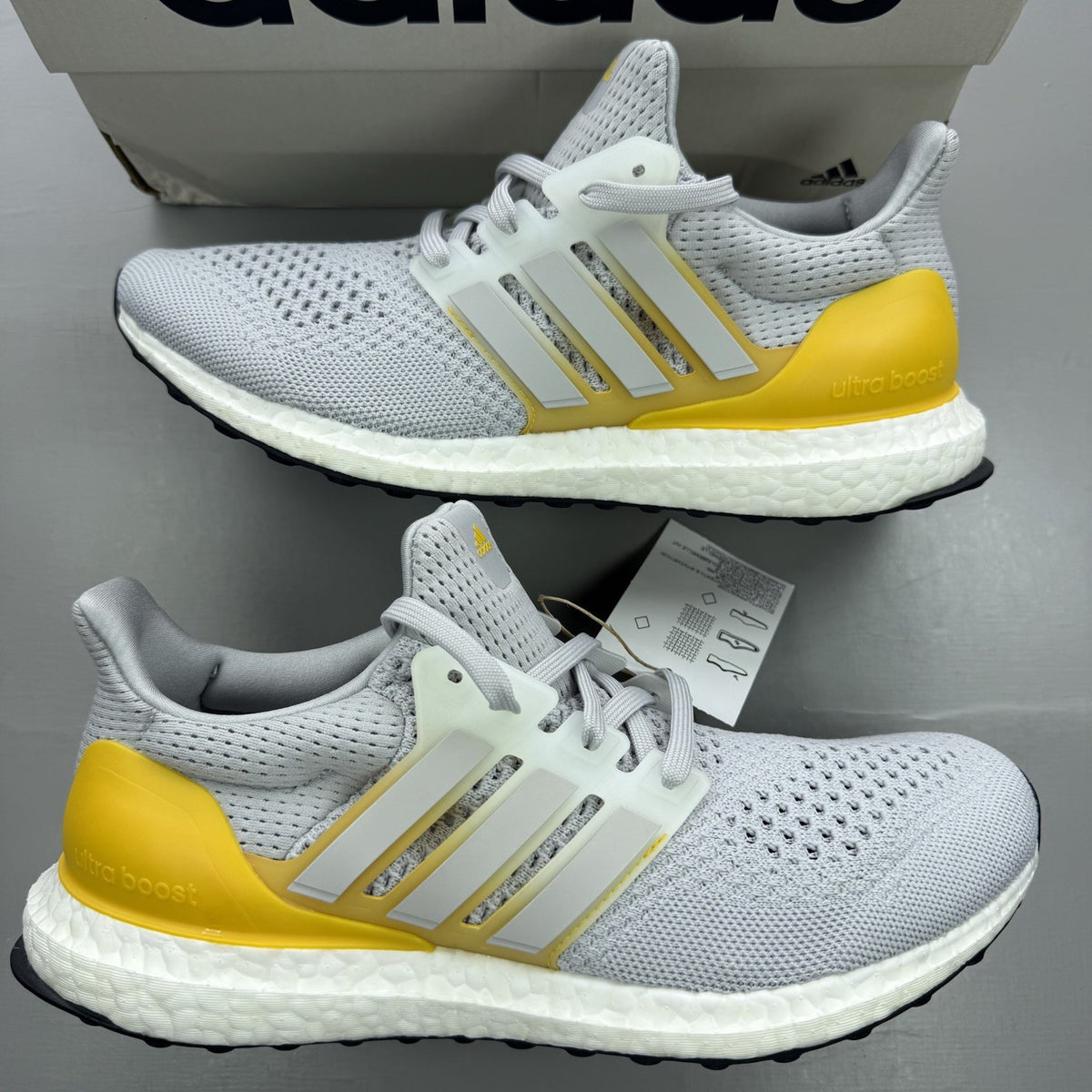 Adidas Ultra Boost 1.0 grey trainers with bold gold accents and white sole.