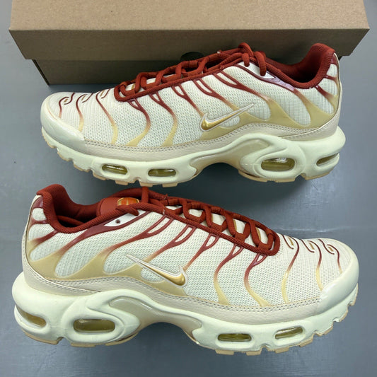 Nike Air Max Plus TN gold trainers with red accents and signature logo detailing.