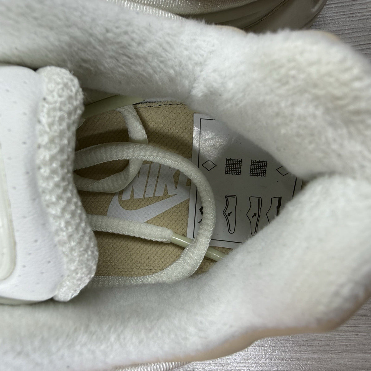 Nike Air Max Deluxe SE beige trainers with unique pattern and logo details.