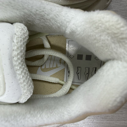 Nike Air Max Deluxe SE beige trainers with unique pattern and logo details.