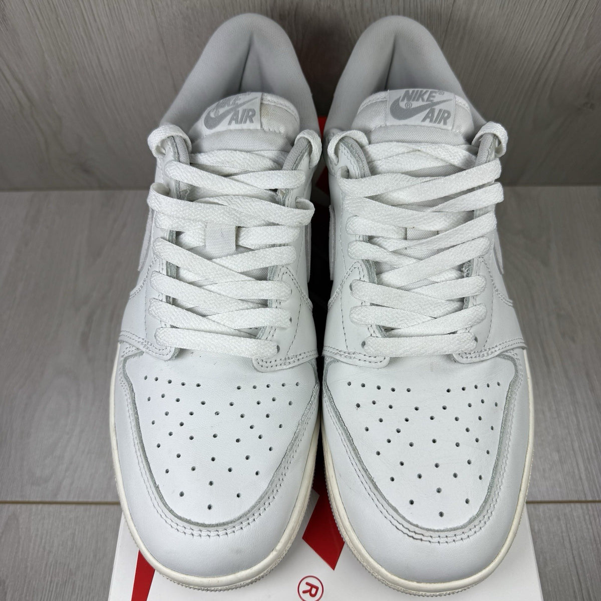Nike Air Jordan 1 Low 85 grey trainers with white accents and iconic swoosh logo.