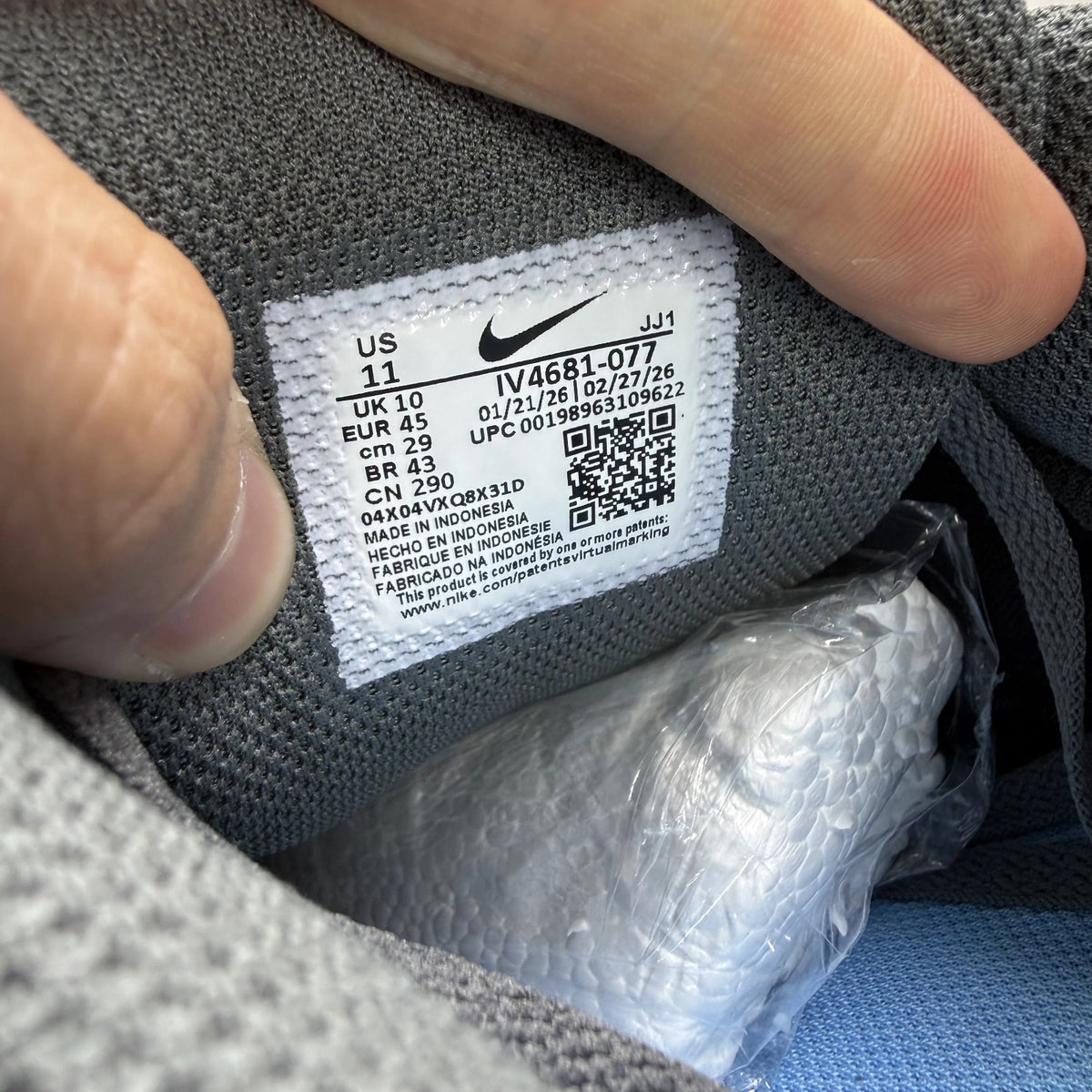 Nike Air Max 90 grey trainers with blue accents and logo detail.