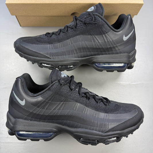 Nike black trainers with light grey accents and signature Air Max cushioning.