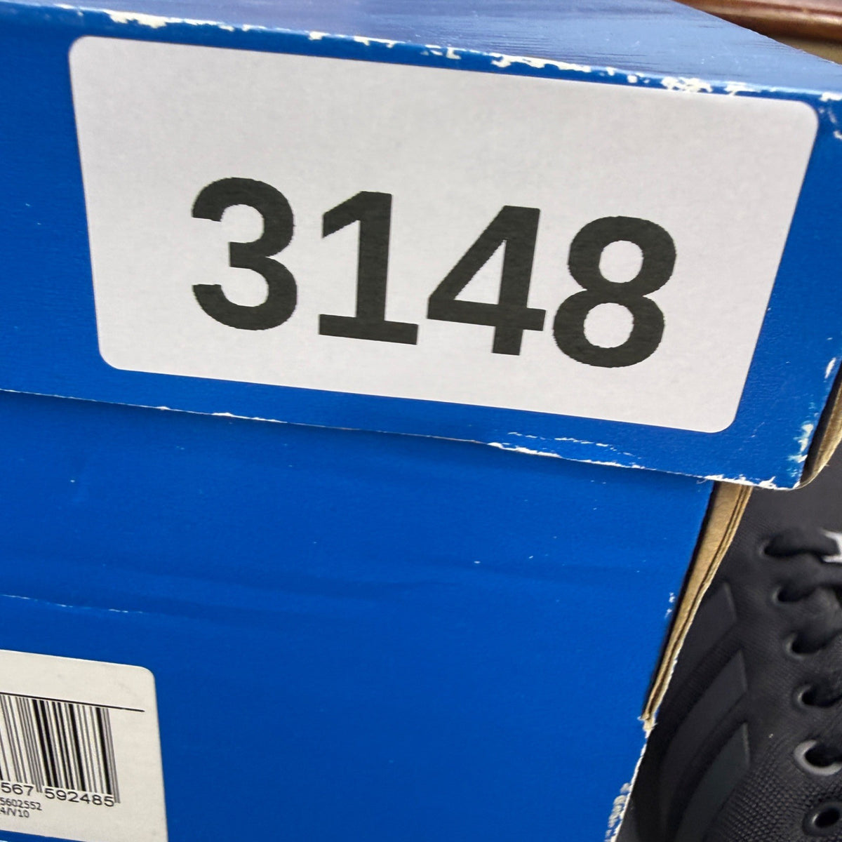 Adidas black trainers with iridescent accents and signature logo on tongue.